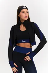 Conjunto deportivo de tres piezas compuesto por una campera corta con cierre frontal, un top deportivo y una calza larga. Las prendas presentan un diseño texturizado en color negro con detalles en azul eléctrico en los laterales y pretinas.