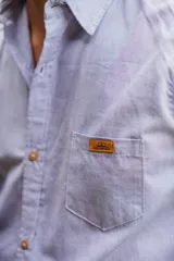 Camisa blanca de manga larga, de corte clásico y holgado, confeccionada en algodón con botones de madera.