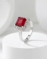 Anillo de plata 925 con piedra central de raíz de rubí en corte rectangular, rodeada por un halo de circonias brillantes.