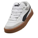 Championes Puma modelo Park Lifestyle SK8, de diseño urbano inspirado en el skate. Presentan una base de cuero blanco con detalles en gamuza gris claro en la puntera y el talón, destacando la icónica franja lateral de Puma en color negro. La suela es de goma color caramelo, proporcionando un contraste clásico y duradero.