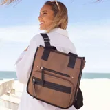 Mochila y cartera híbrida confeccionada en nylon de color beige con detalles y correas en negro. Posee dos asas superiores para llevar al hombro y correas traseras ajustables para usar como mochila. Presenta dos bolsillos frontales con cierre de cremallera y tiradores largos.