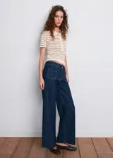 Jeans de denim azul oscuro con diseño wide leg, tiro alto, bolsillos de parche delanteros y cierre frontal de cremallera y botón.