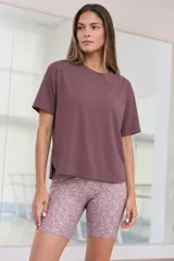 Remera de fitness color bordó, de corte holgado, cuello redondo y mangas cortas. Confeccionada en tejido técnico de secado rápido.