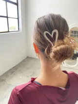 Pinza dorada para el pelo con detalle en forma de corazón.