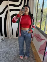 Polera de manga larga, ajustada al cuerpo, color rojo, con cuello redondo y un pequeño logo bordado en el pecho.