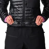 Campera puffer negra de Mountain Hardwear, con diseño acolchado, cierre frontal completo, cuello alto y bolsillo con cierre en el pecho. Cuenta con puños elásticos en color lila y ajuste en el dobladillo.