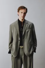 Blazer de corte relaxed fit confeccionada en tejido con mezcla de modal, en color verde militar. Presenta cuello con solapas de muesca, cierre frontal con un botón, bolsillos de vivo en el pecho y bolsillos con solapa en la cadera. Forro interior a rayas y abertura en el centro de la espalda.