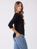 Remera básica de algodón con cuello redondo y mangas tres cuartos. Presenta un corte ajustado y ruedo redondeado.
