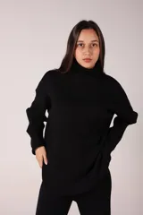Conjunto de dos piezas compuesto por un sweater de cuello alto y pantalón de corte recto, ambos confeccionados en tejido de punto acanalado.