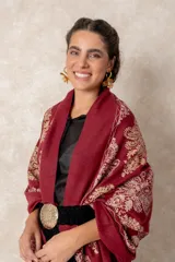 Pashmina de tela densa y suave, con caída pesada y diseño bordado con motivos florales en tonos dorados y beige. Presenta terminaciones con flecos en los extremos.