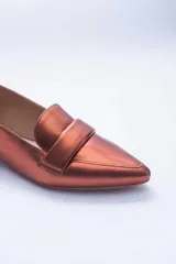Mocasines negros de cuero con punta fina y detalle de antifaz.