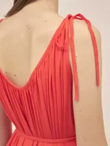 Vestido largo de crepe color rojo, con escote en V profundo, breteles finos ajustables con nudos y detalle de cordón ajustable en la cintura con terminales metálicas.