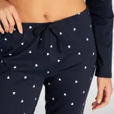 Conjunto de pijama azul marino de dos piezas: camiseta de manga larga con un corazón rojo bordado en el pecho y pantalón largo con estampado de corazones blancos.