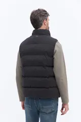 Chaleco puffer de nylon con diseño matelaseado, cuello alto y cierre frontal. Cuenta con bolsillos laterales y un pequeño parche con logo en el pecho.