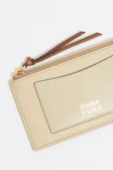 Monedero Bimba y Lola de piel vacuna con textura granulada, color verde menta. Presenta cierre con cremallera, tirador de cordón en color naranja, tarjetero exterior y logo de la marca grabado en dorado.