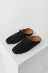 Zueco tipo mule de pelo corto, color negro, con punta cuadrada y plantilla de cuero.