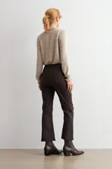 Pantalón de corte cropped y tiro alto, con acabado engomado en color chocolate. Presenta diseño de cinco bolsillos y cierre frontal con botón y cremallera.