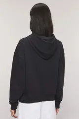 Buzo negro con capucha y mangas largas, confeccionado en rústico de algodón con bordado frontal de texto en color blanco.