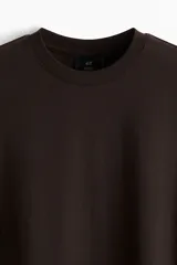 Remera de punto de algodón liviano color marrón oscuro, con cuello redondo ribeteado y bajo recto. Corte estándar para una silueta clásica y cómoda.