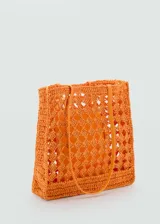Bolso tipo shopper de diseño calado, confeccionado en tejido de fibra natural color naranja. Cuenta con doble asa larga para llevar al hombro y un bolsillo interior.