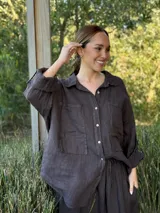 Camisa negra de manga larga con cuello clásico y cierre frontal con botones.