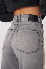 Pantalón de tiro medio con corte baggy y pierna recta. Confeccionado en denim con un proceso de transferencia que le otorga una textura metalizada con efecto de piel de cocodrilo en tonos grisáceos.