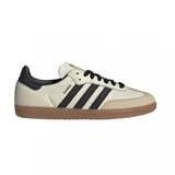Championes Adidas modelo Samba OG, con diseño clásico de perfil bajo, parte superior de cuero en tono crema, icónicas tres tiras laterales en negro, refuerzo de gamuza en la puntera y suela de goma color caramelo.