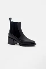 Bota corta tipo chelsea de cuero, con taco cuadrado y punta cuadrada. Presenta paneles laterales elásticos y una suela con plataforma sutil.