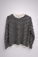 Saco tejido de punto con diseño de rayas horizontales en color negro y beige. Presenta cuello redondo, cierre frontal con botones y textura suave.