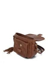 Cartera bandolera color chocolate, confeccionada en una combinación de cuero sintético liso y gamuza en la solapa frontal. Presenta un diseño estructurado con cierre de solapa, detalles de costuras visibles, herrajes metálicos en tono bronce y un adorno de borlas de cuero colgantes en un lateral.