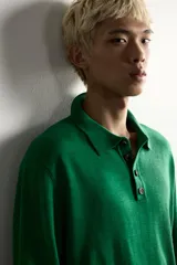 Polo de punto de manga larga en color verde, confeccionado en hilatura de lana. Presenta cuello solapa, cierre frontal con botonadura y acabados en rib en puños y bajo.