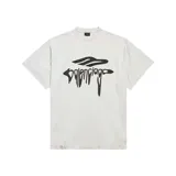 Camiseta de algodón color blanco con corte oversize, cuello redondo y efecto desgastado en bordes. Presenta estampado gráfico frontal en color negro con el logo de la marca en estilo líquido.