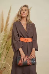 Saco largo color chocolate con cuello en V, mangas anchas y detalle de flecos en el ruedo. Se ajusta con un cinturón ancho color naranja.