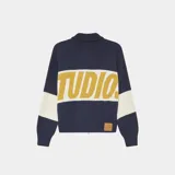 Buzo tejido de punto con cierre frontal metálico, cuello polo y diseño oversize. Presenta bloques de color en azul marino, blanco y amarillo con el logo de la marca tejido en técnica jacquard en el frente.
