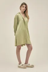 Camisola color verde pistacho, de corte holgado, confeccionada en lino y tencel. Tiene cuello camisero, mangas largas con puños abotonados, cierre frontal con botones y bolsillos laterales.