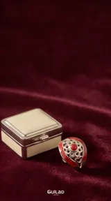 Anillo de plata 925 con diseño calado de motivos florales y corazones, decorado con esmalte rojo y una piedra central circular.