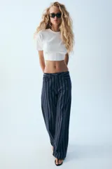 Jeans de tiro medio y corte recto, con diseño de rayas verticales en tonos de azul. Cuenta con trabillas, cinco bolsillos y cierre frontal con cremallera y botón metálico.