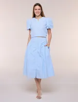 Falda midi abotonada de textura gofrada y diseño a rayas. Presenta cintura ancha entallada, abotonadura frontal completa, corte con frunce para mayor amplitud y bolsillos laterales funcionales. Cuenta con forro interno.