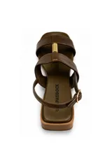 Sandalia de taco bajo marca Paddock, color verde oscuro, con tiras anchas, pulsera regulable con hebilla lateral y detalle metálico dorado en el centro. Cuenta con punta cuadrada.