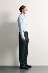Camisa negra de corte regular fit, cuello italiano, manga larga con puño abotonado y cierre frontal con botones.