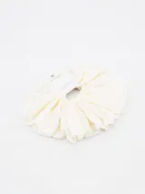 Colero de tela color crudo con textura arrugada.