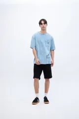 Remera celeste con efecto marmolado, bolsillo en el pecho con parche decorativo y arte en la espalda baja. De calce oversize y algodón lavado con textura extra suave.