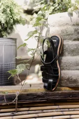 Sandalias de cuero con tiras entrecruzadas, suela plana y hebilla lateral.