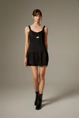 Vestido corto de poliéster color negro con estampado de lunares brillantes tipo strass, tirantes finos con volados, escote con abertura cut-out en el centro y falda con volado fruncido en el borde inferior.