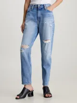 Pantalón de jean celeste con roturas en ambas piernas, de corte mom y tiro alto. Confeccionado con 79% algodón y 21% algodón reciclado.