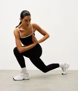 Pantalón deportivo tipo legging de la marca Get Over, confeccionado en microfibra elástica con cintura cruzada y detalle de viés contrastante.