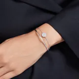 Pulsera plateada con doble cadena y dije circular con incrustaciones de cristales blancos.