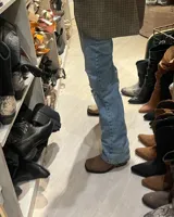 Bota de cuero marrón con caña alta y estribo desmontable.