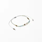 Pulsera elástica con cuentas de vidrio color celeste, cuentas doradas y un dije de piedra blanca.