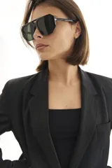 Lentes de sol con armazón de policarbonato negro y cristales tonalidad ámbar, con diseño de puente doble estilo aviador.